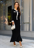 Woman in a black outfit with white accents walking in front of a Tom Ford store.