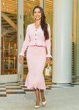  A romantic and versatile pink knit set with intricate pointelle detailing, a flattering midi skirt, and a relaxed-fit cardigan.