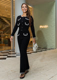 Woman in a black outfit with white accents standing in front of a luxury store.