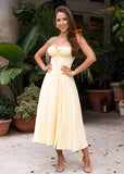 A soft yellow sundress with a flattering bustier top and flowy silhouette, perfect for summer days, garden parties, or warm-weather getaways.
