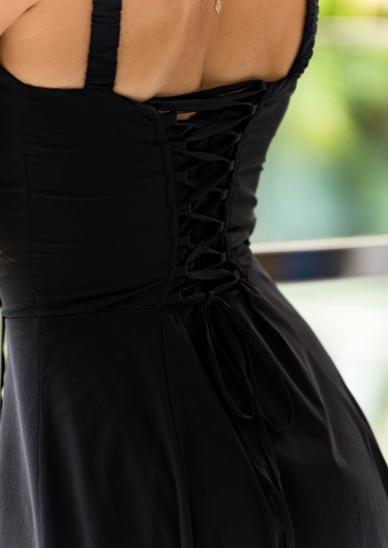 Isabel black sundress styled for springtime with floral heels and soft curls.