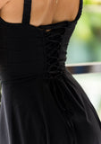Isabel black sundress styled for springtime with floral heels and soft curls.