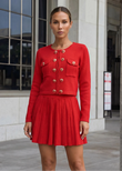 Red embellished knit cardigan and pleated mini skirt set with crystal heart buttons.