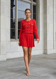 Front view of a red knit cardigan paired with a pleated mini skirt featuring crystal heart buttons from shoppegasi.