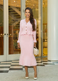 A soft and stylish pink pointelle knit two-piece set featuring a high-waisted midi skirt and a lightweight cardigan for everyday elegance.
