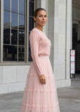 Elegant blush pink knit cardigan paired with tiered tulle maxi skirt featuring pearl buttons from shoppegasi.