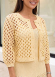 Model wearing buttery yellow open-knit cropped cardigan layered over knit dress