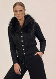 Woman in black knit cardigan and wide-leg pants set with hand in pocket, dynamic pose