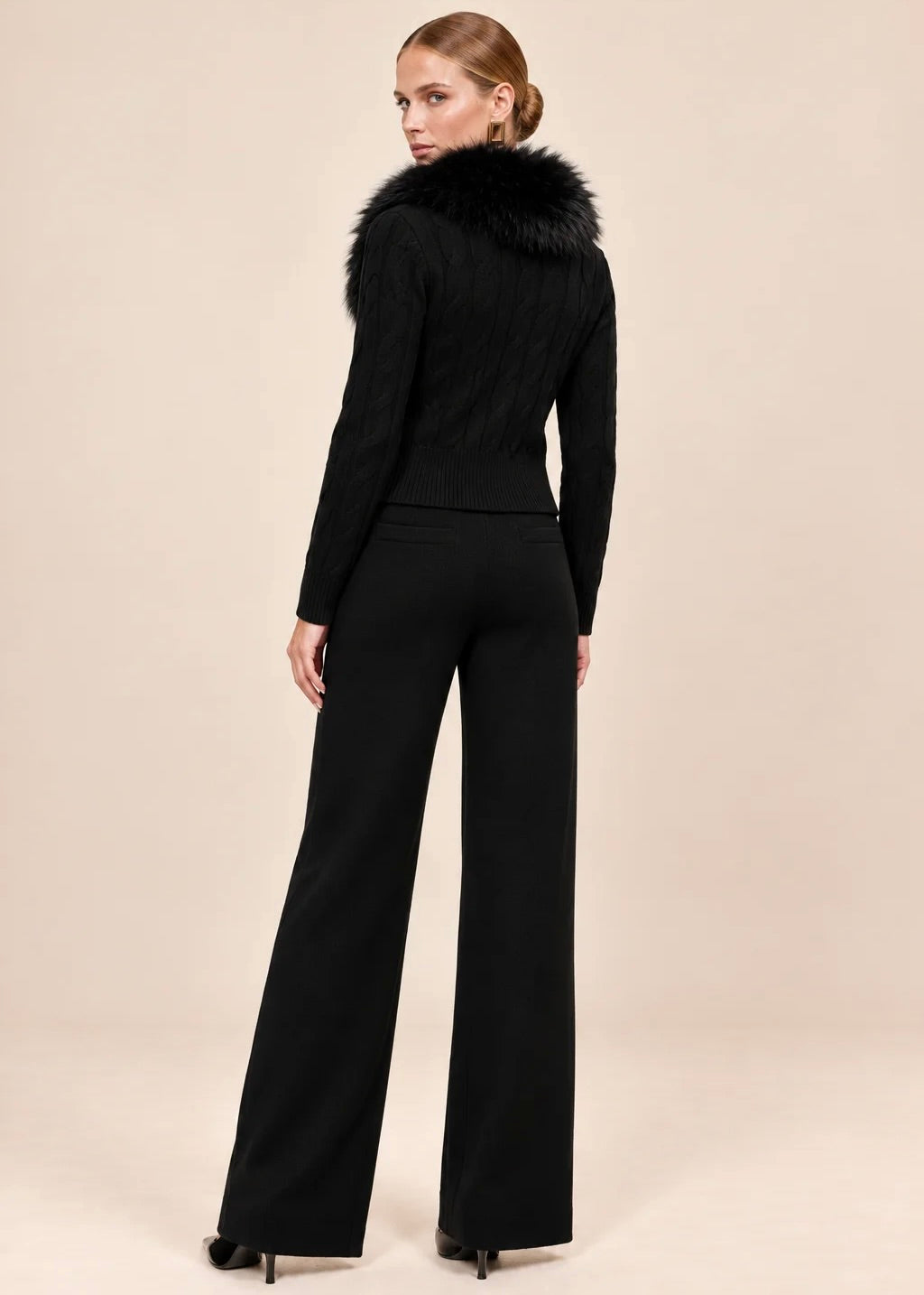 Back and side view of woman walking in black knit cardigan and wide-leg pants set