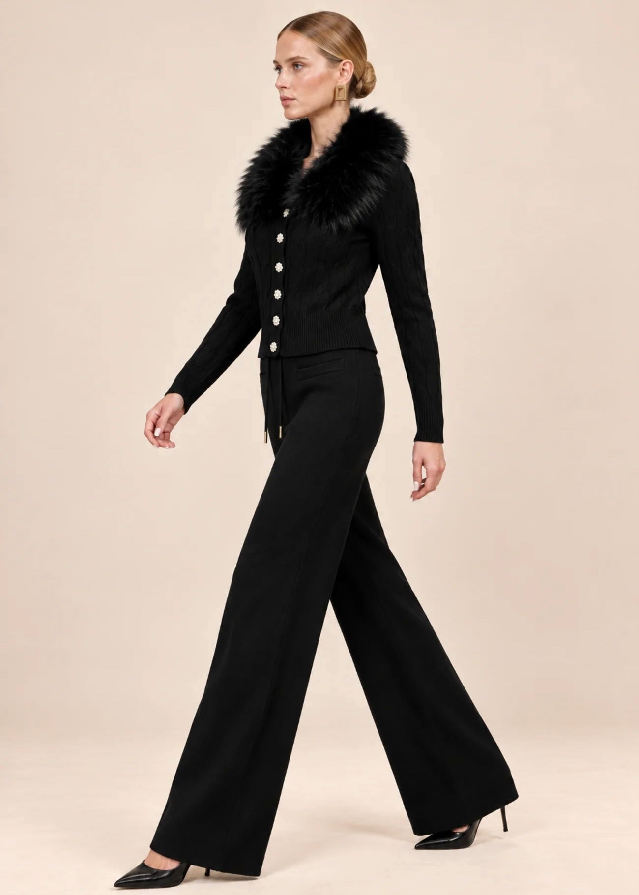 Woman walking in black knit cardigan and wide-leg pants set, side profile