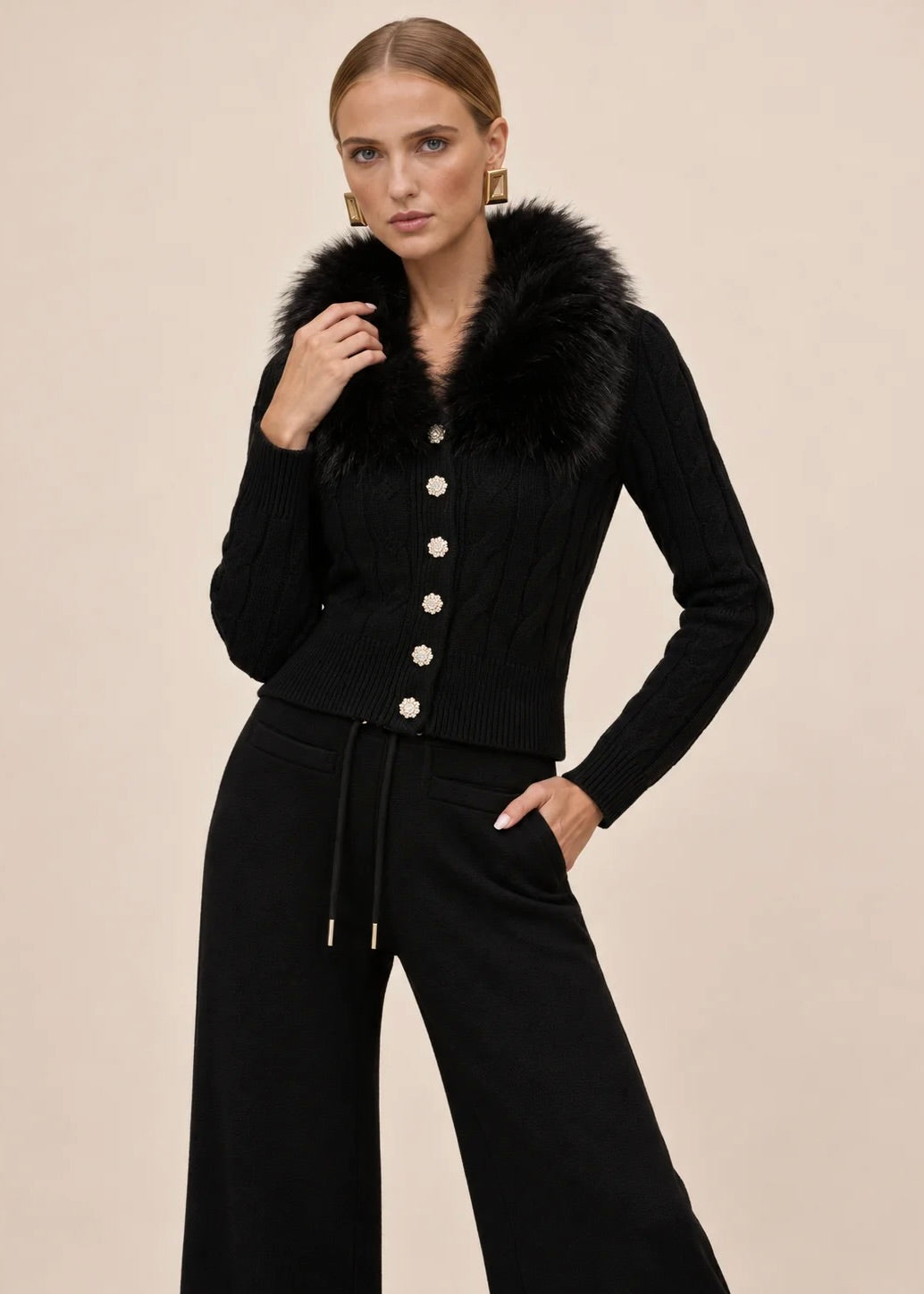 Woman stepping forward in black knit cardigan and wide-leg pants set