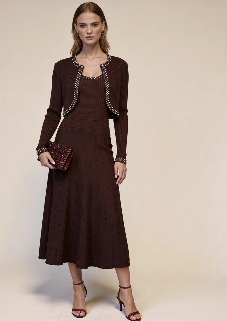 Full-length view of burgundy knit midi dress and matching pearl-trim cardigan styled with burgundy heels and an embellished evening clutch.