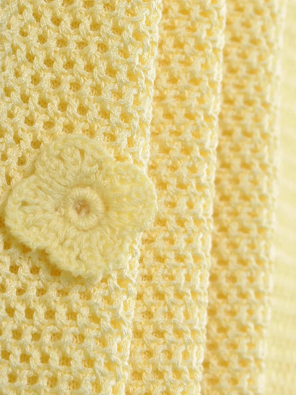 close-up of 3D floral appliqués on yellow crochet peplum mini dress