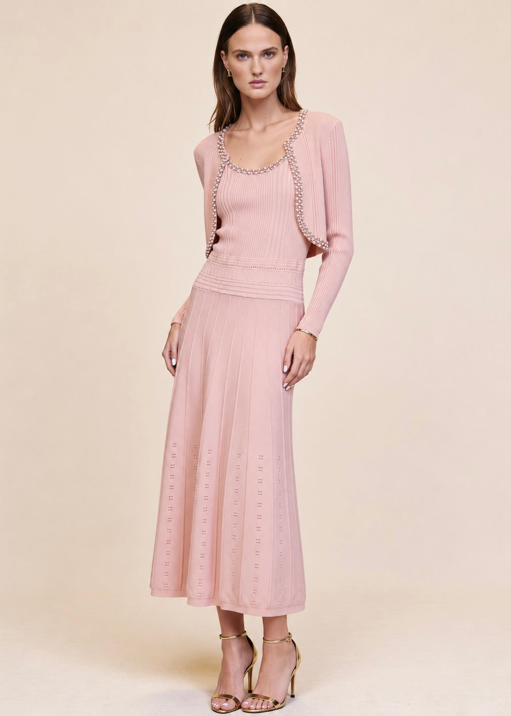 Pink ribbed knit cardigan worn open over matching pearl and crystal trim midi dress