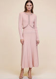 Pink ribbed knit cardigan buttoned closed over pearl and crystal trim midi dress, full body