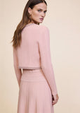 Close-up back view of pink ribbed knit cardigan and dress set showing pearl and crystal trim detail