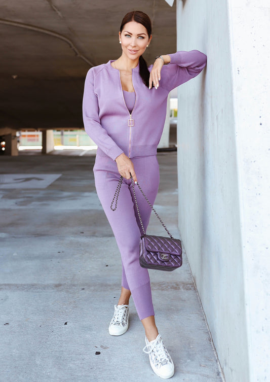 Model wearing a lavender 3-piece outfit featuring joggers, a golden-detailed top, and a cardigan with a chic gold zipper, crafted to enhance body curves.