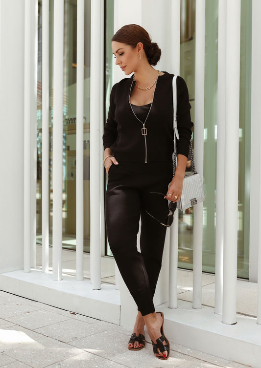 A sleek black three-piece knitwear set, featuring a cozy cardigan, fitted top, and relaxed pants—perfect for layering and all-day comfort.